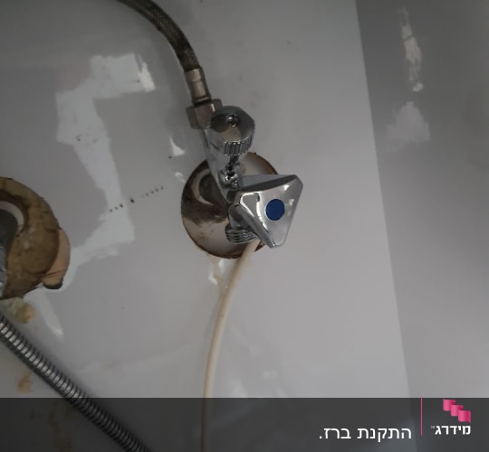 ברז מתכת עם צינור גמיש מתחת לכיור